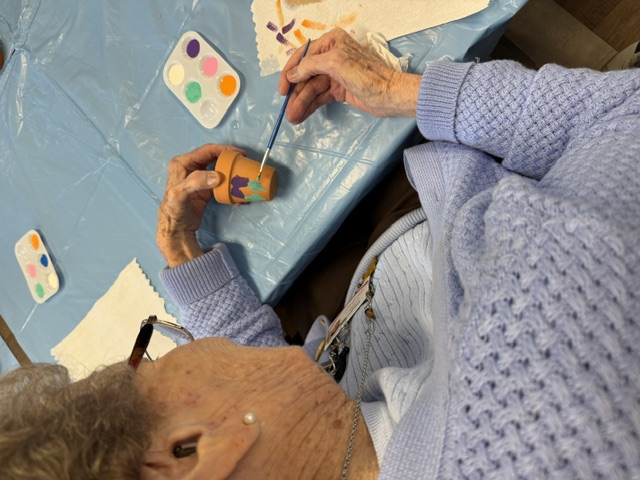Senior painting a flower pot